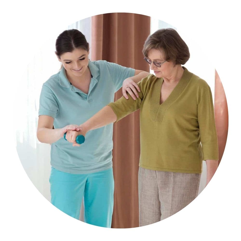 Ältere Patientin bei Physiotherapie mit Therapeutin zuhause